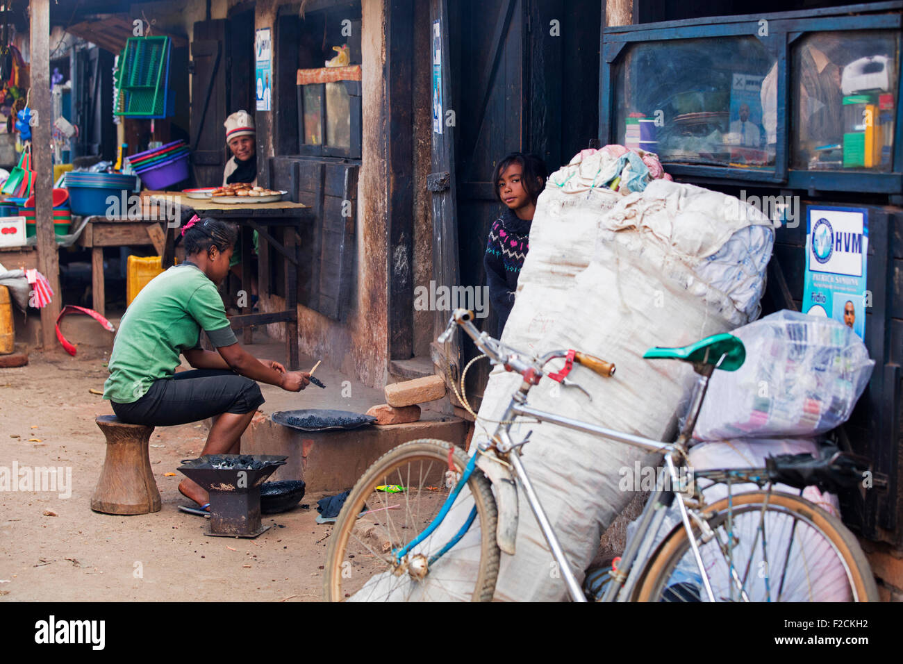 Donna malgascia cottura su carbone in polvere della strada dello shopping della città, Ambalavao Haute Matsiatra, Madagascar, Africa Foto Stock