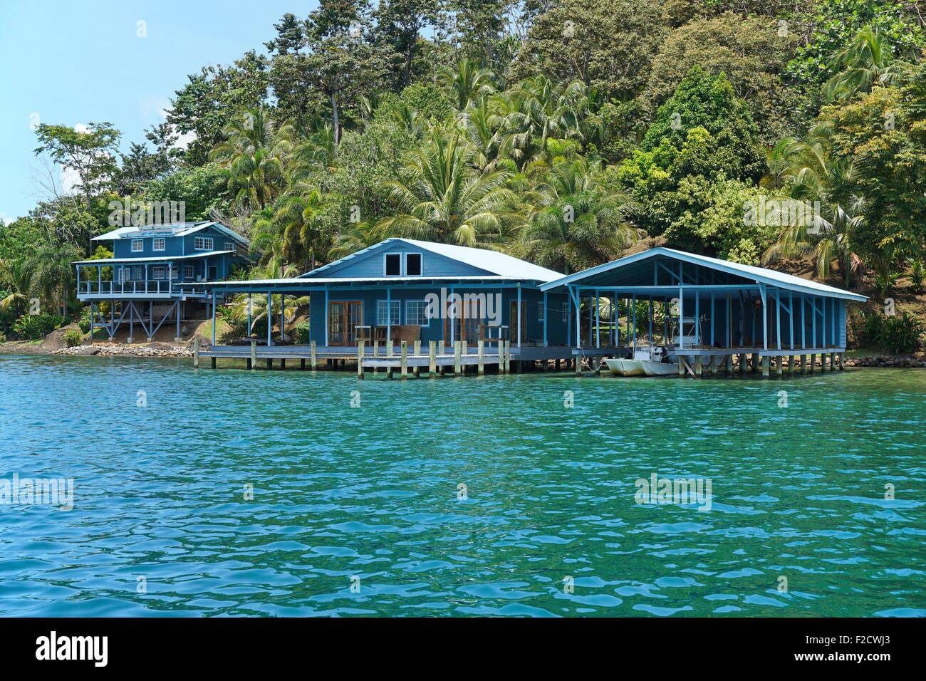 Caraibi home e boat house sull'acqua con lussureggiante vegetazione tropicale sulla costa, Panama America Centrale Foto Stock