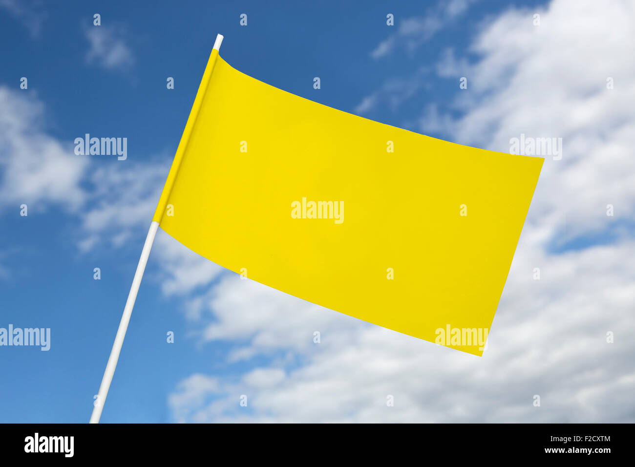 Bandiera gialla nella parte anteriore di un cielo blu Foto Stock