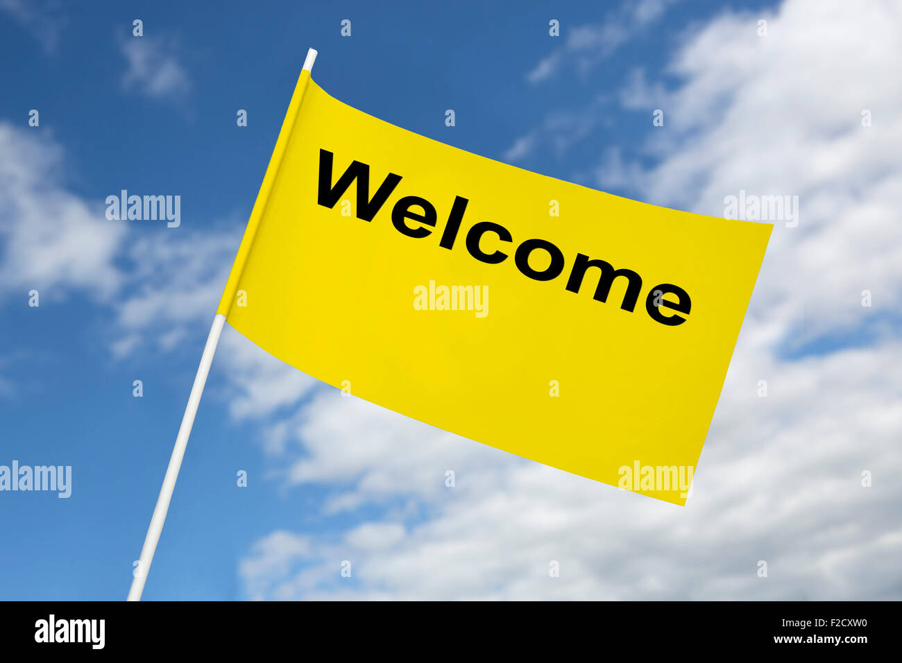 Bandiera gialla benvenuti nella parte anteriore di un cielo blu Foto Stock