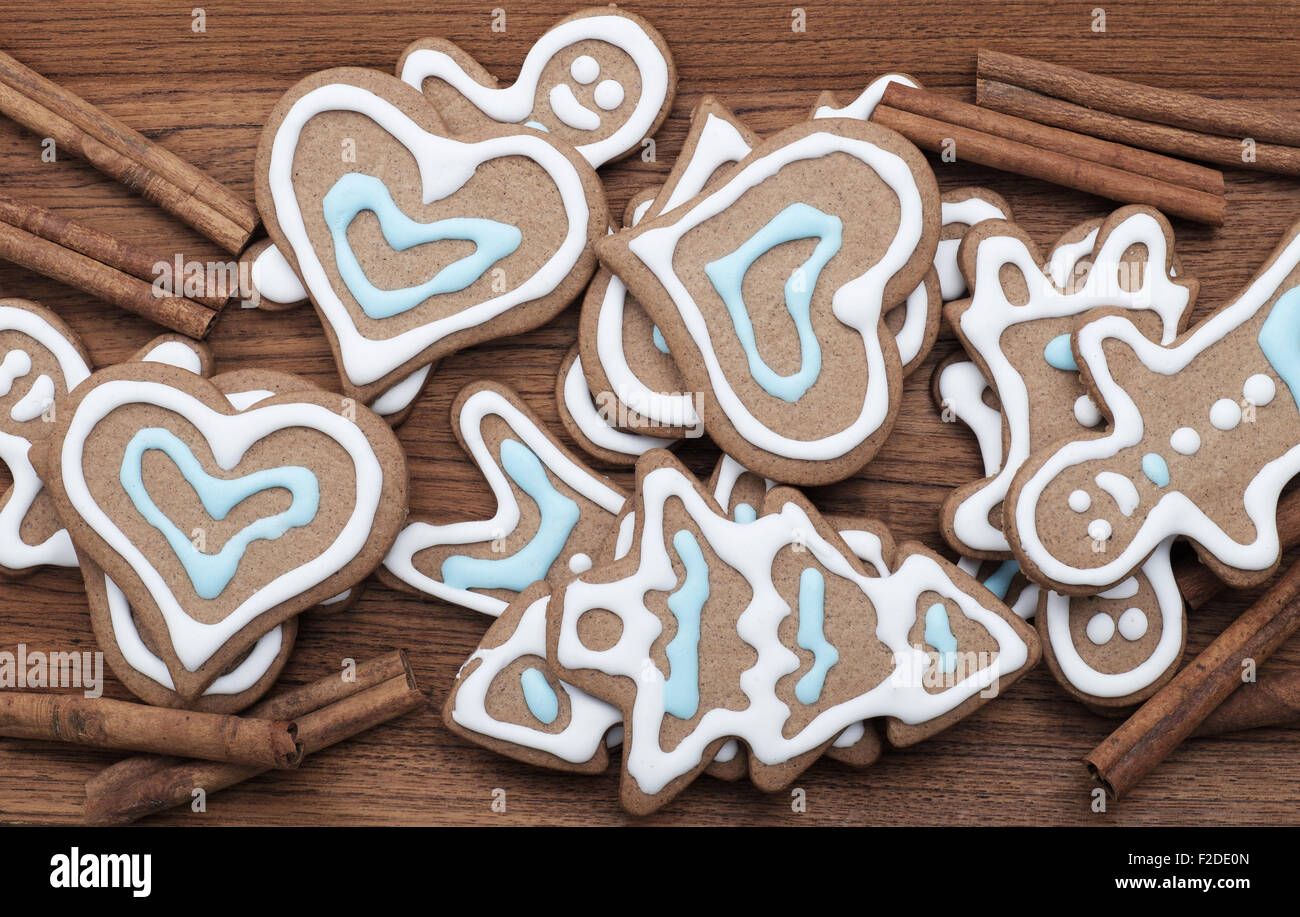 Decorate gingerbread cookies con bastoncini di cannella su uno sfondo di legno Foto Stock
