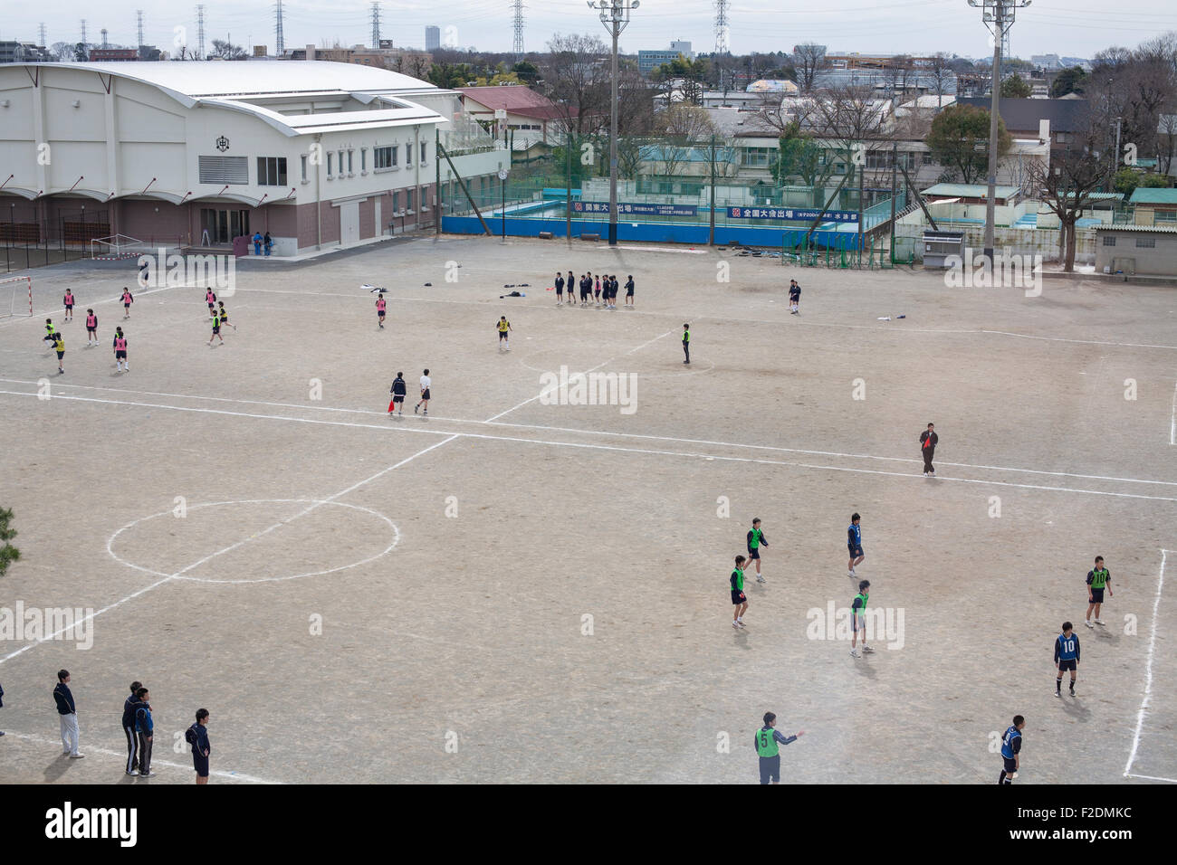 La sporcizia schoolyard con ragazzi che giocano a calcio pov da sopra al centro spazio aperto Foto Stock