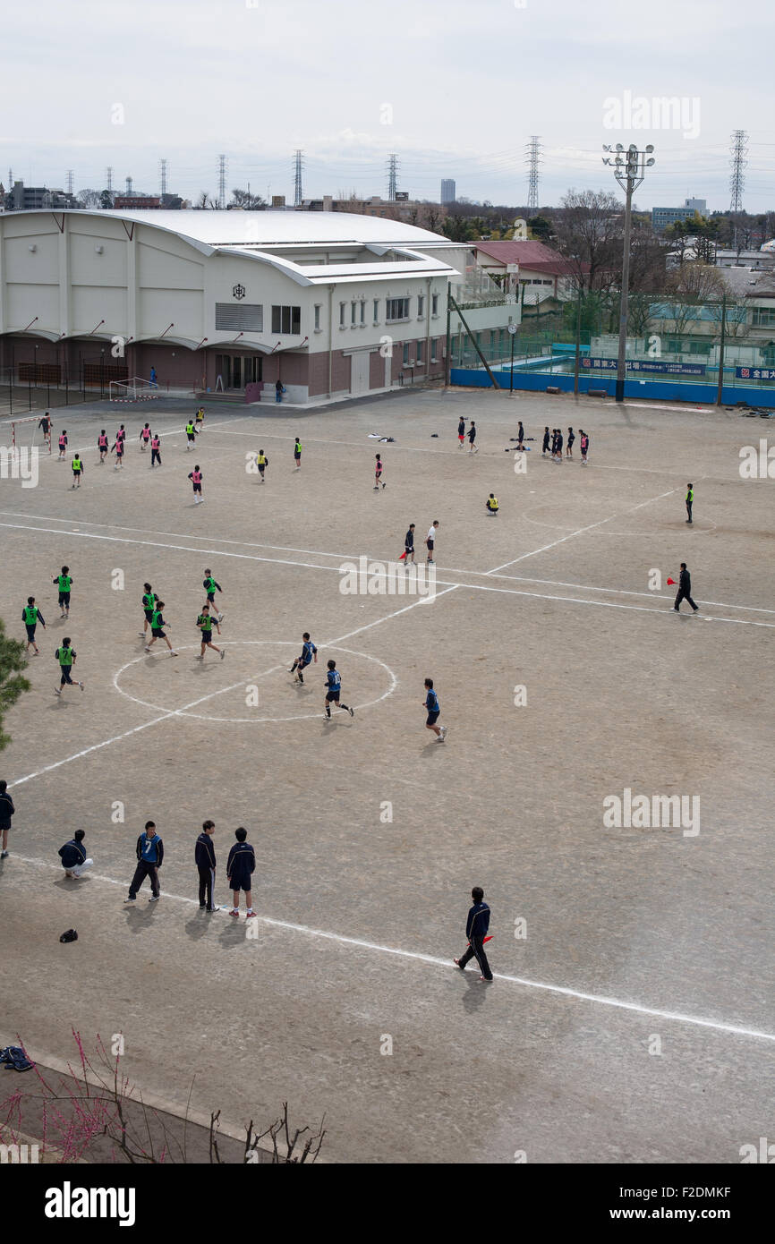 La sporcizia schoolyard con ragazzi che giocano a calcio pov da sopra a destra spazio aperto Foto Stock