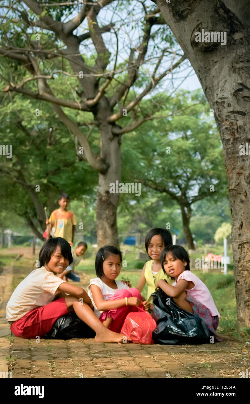 Ritratto dei bambini che stanno lavorando raccogliendo rifiuti di plastica al cimitero pubblico di Pondok Kelapa a Giacarta Est, Indonesia. Foto Stock