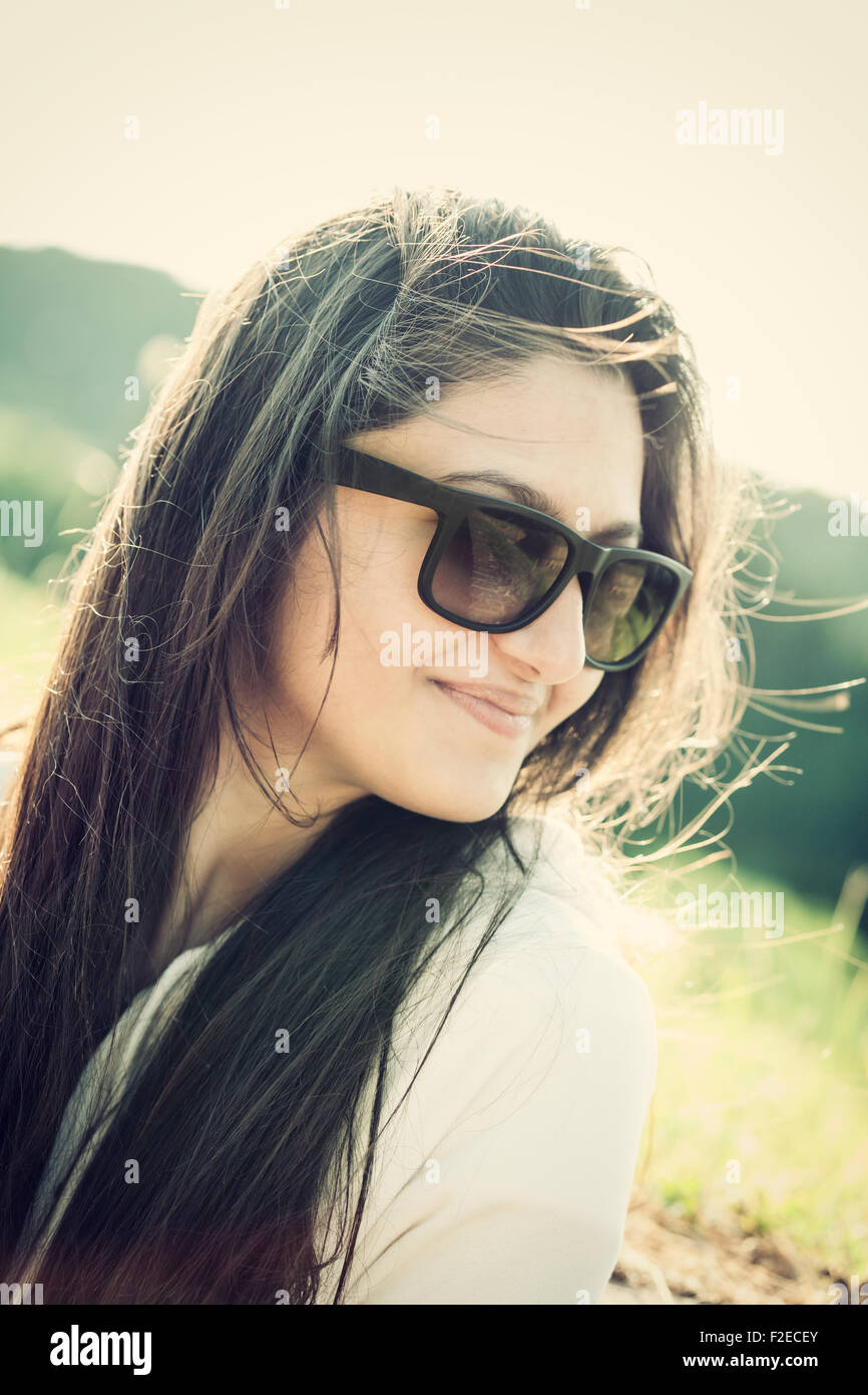 Ritratto di un adolescente con occhiali da sole fotografato in controluce Foto Stock