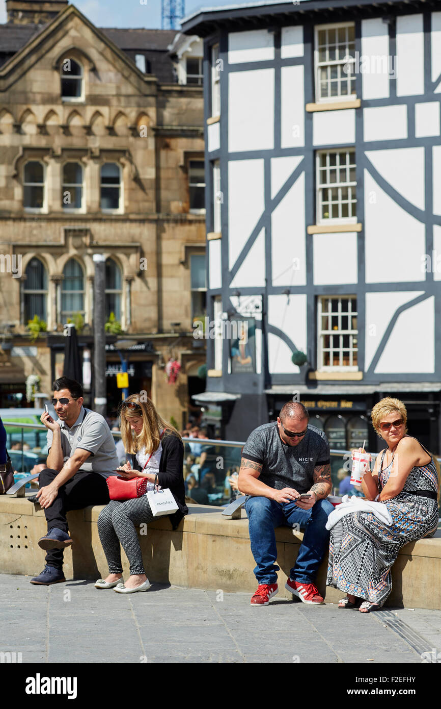 La gente di relax al sole a Manchester City Centre Dell Exchange Square UK Gran Bretagna British Regno Unito Europa Unione Foto Stock