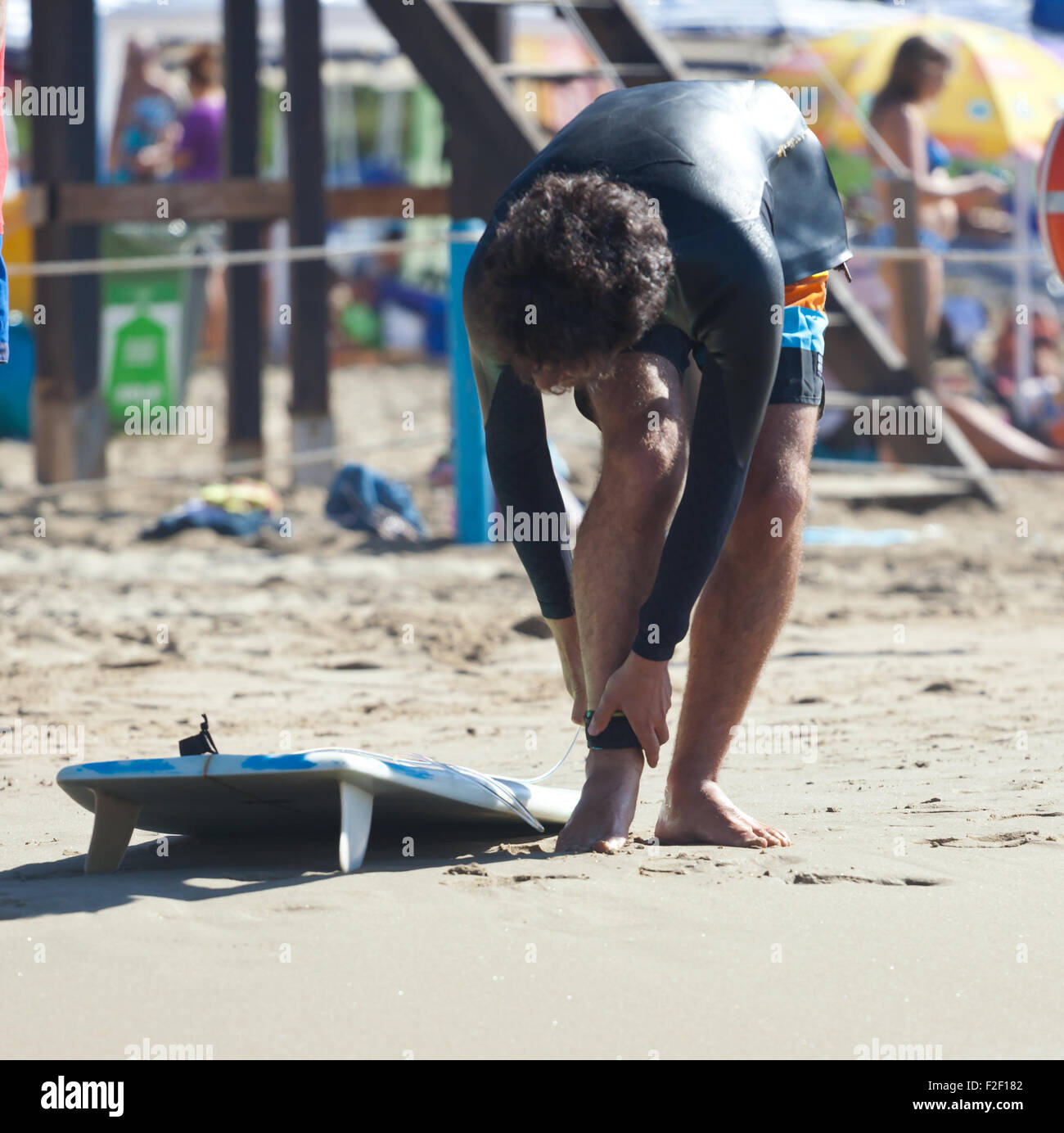 Surfer indossa guinzaglio di sicurezza alla caviglia sulla spiaggia Foto Stock