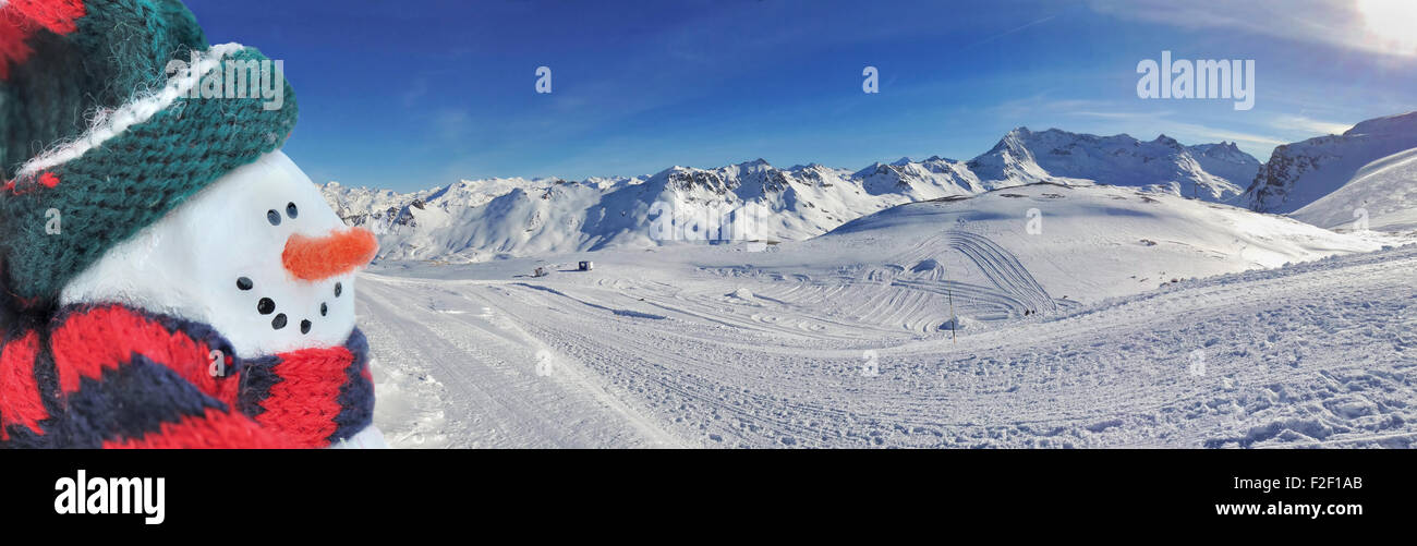 Pupazzo di neve nella parte anteriore del paesaggio panoramico di montagna in inverno Foto Stock