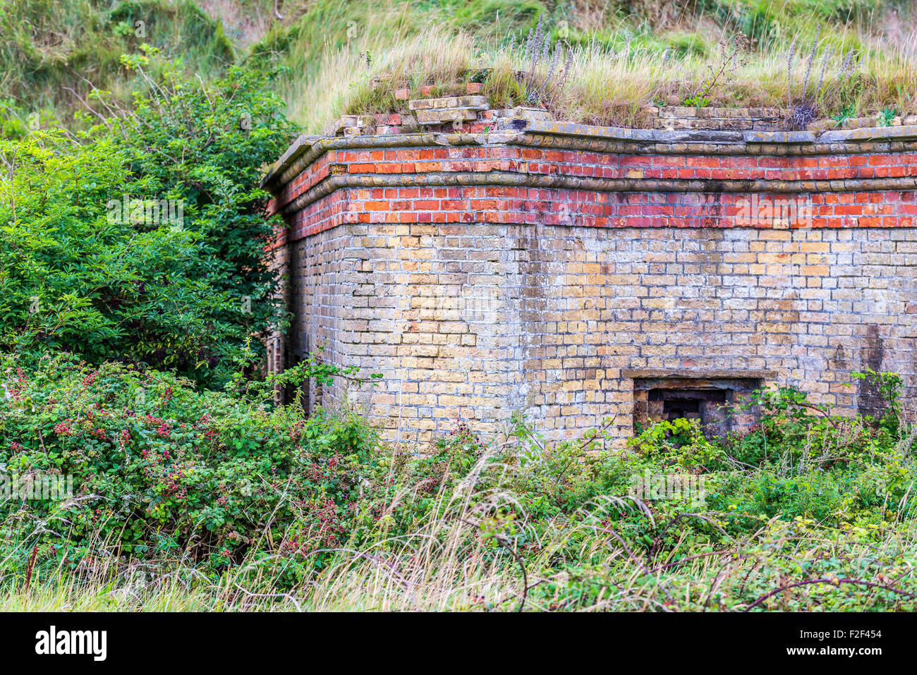 Abbandonato edificio fortificato ai piedi delle scogliere, accanto a una strada in East Sussex Foto Stock