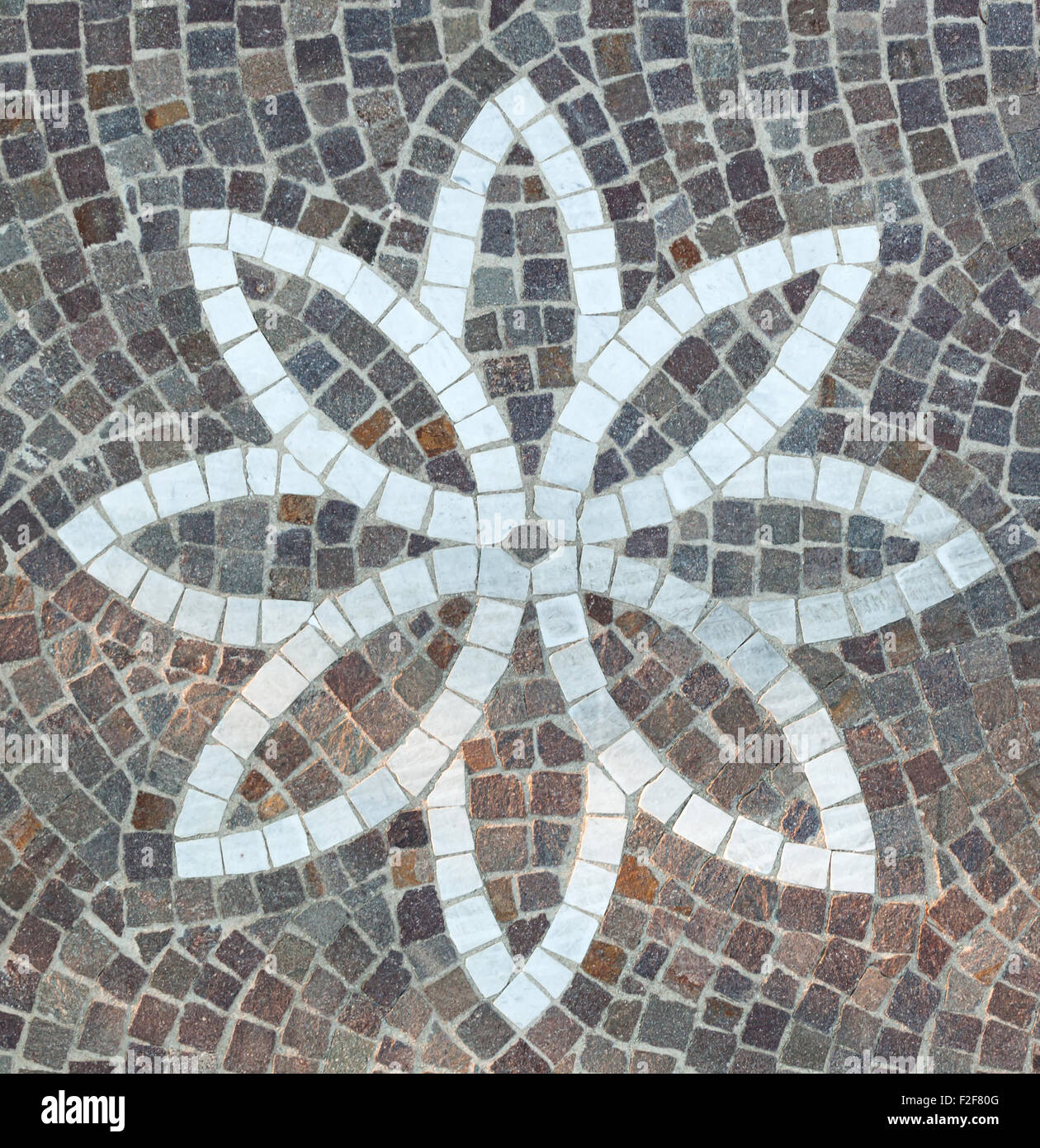 Pavimentazione con ciottoli e a forma di fiore design realizzato con cubetti di marmo. Foto Stock