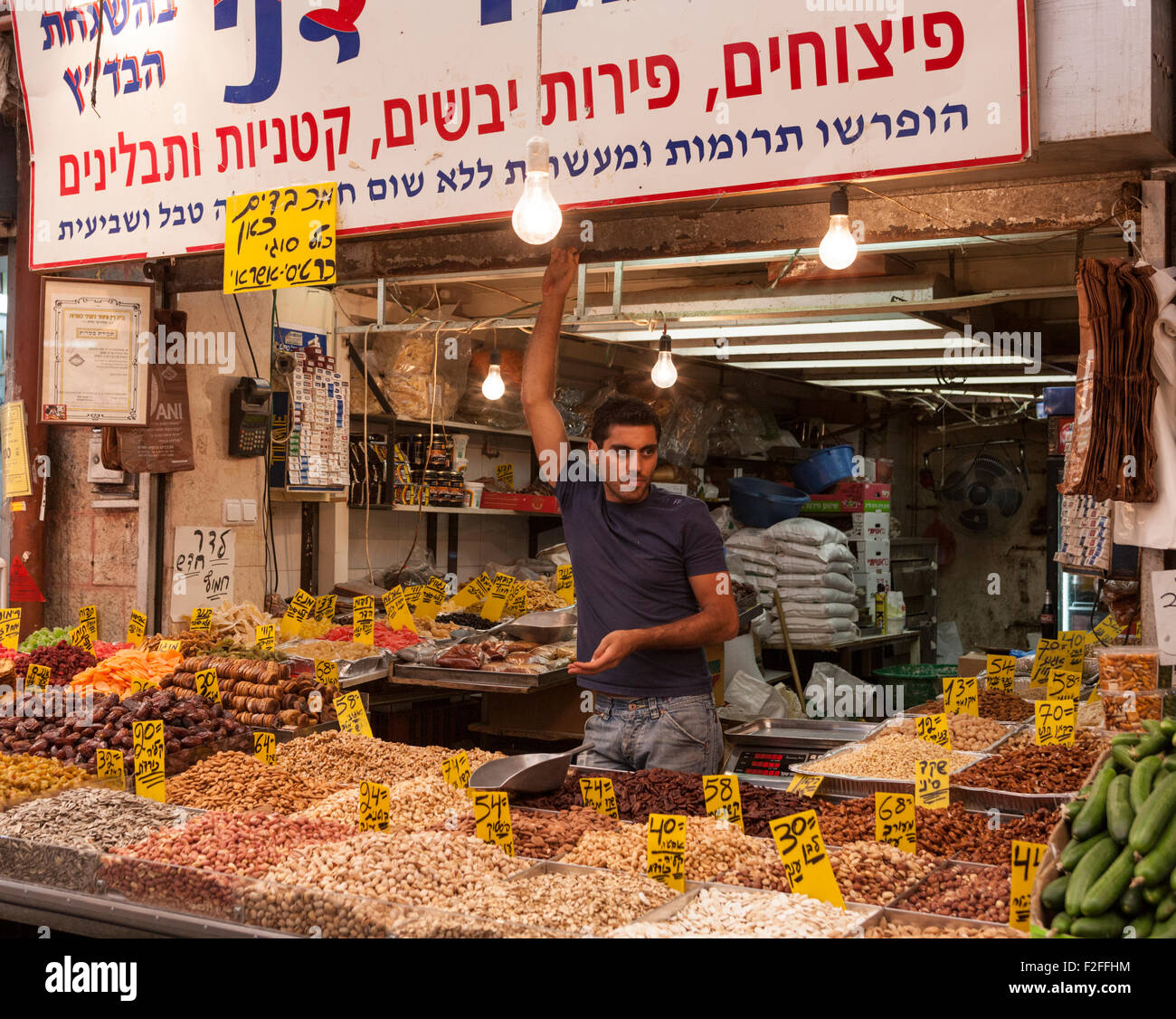 Venditore a vendere frutta secca, comprese le albicocche, date le prugne e uvetta a Mahane Yehuda Market in Jerusalem Israel Foto Stock