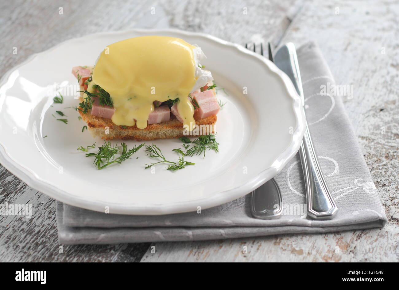 Benedetto le uova con prosciutto sul pane tostato in una padella con lo stile di un romantico Foto Stock