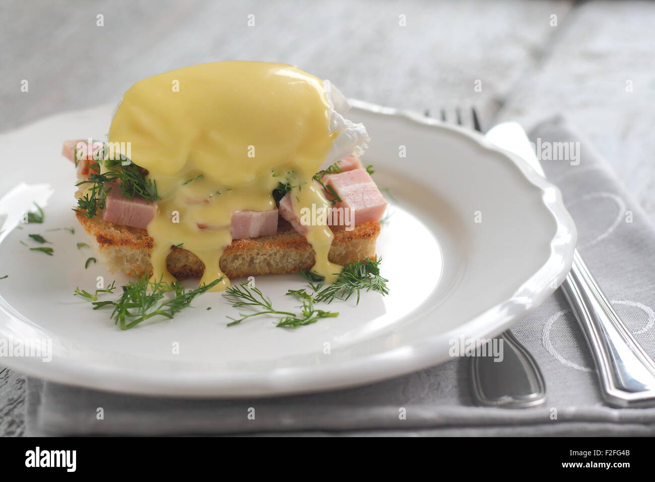 Benedetto le uova con prosciutto sul pane tostato in una padella con lo stile di un romantico Foto Stock