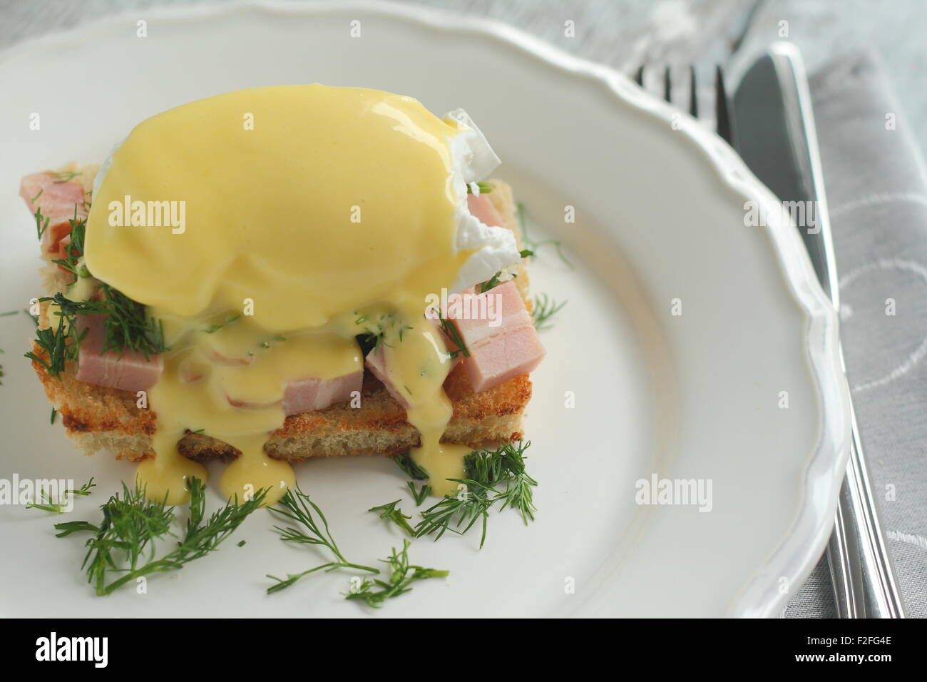 Benedetto le uova con prosciutto sul pane tostato in una padella con lo stile di un romantico Foto Stock