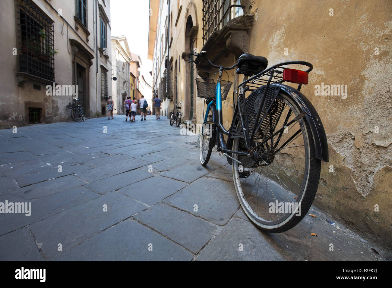 Scena di strada in una città europea, in bicicletta in primo piano con i pedoni in background Foto Stock