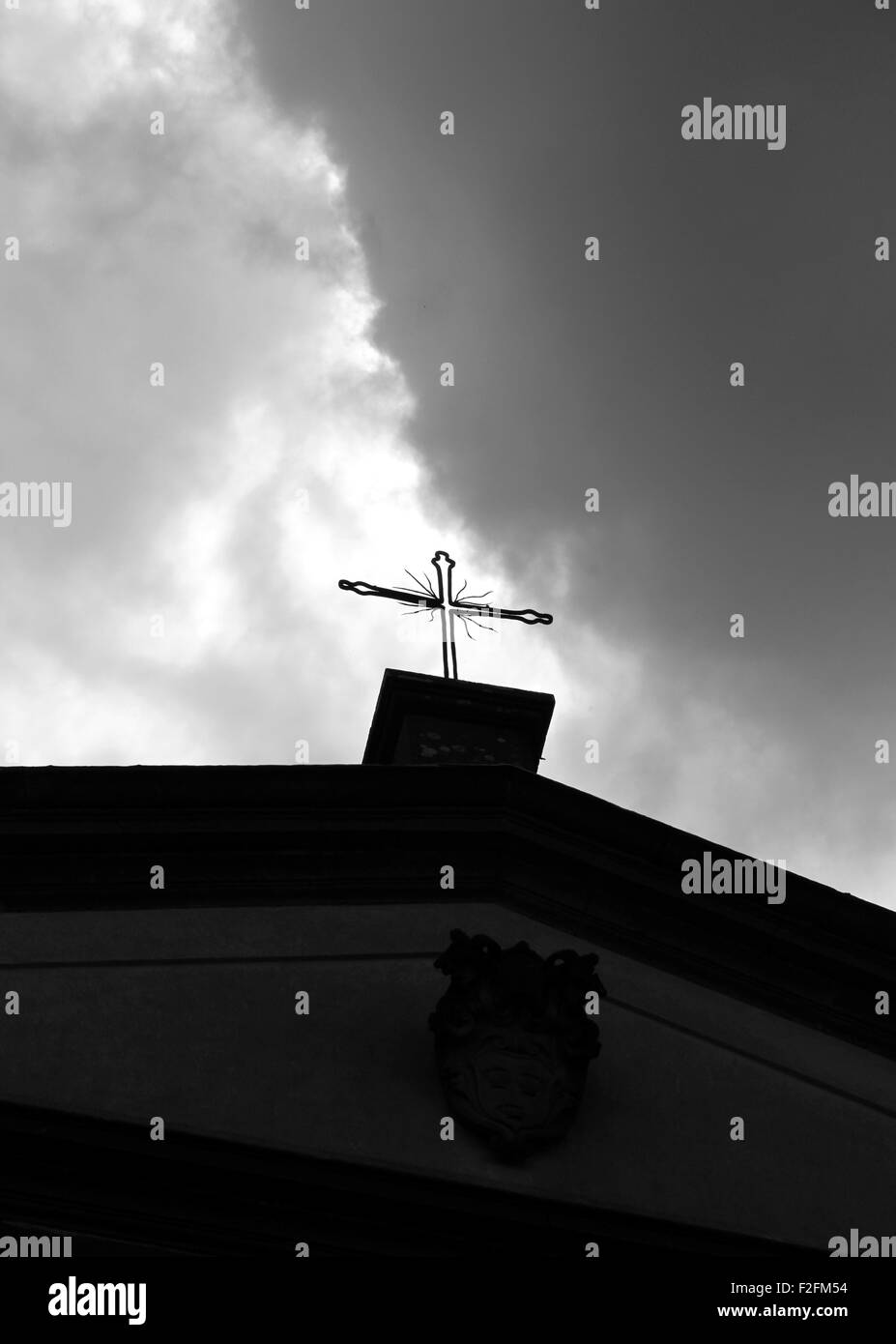 Croce di ferro e il cielo nuvoloso sulla parte superiore di una chiesa in Italia Foto Stock