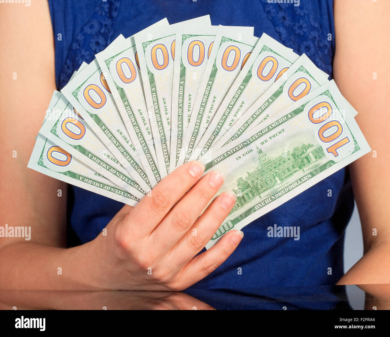 Donna in vestito blu Holding nuovo 100 US Dollar Bills Foto Stock