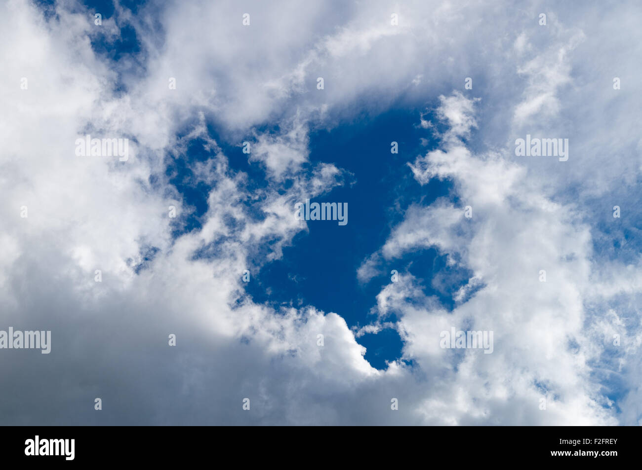 Blue sky lotta attraverso le nuvole pesanti Foto Stock