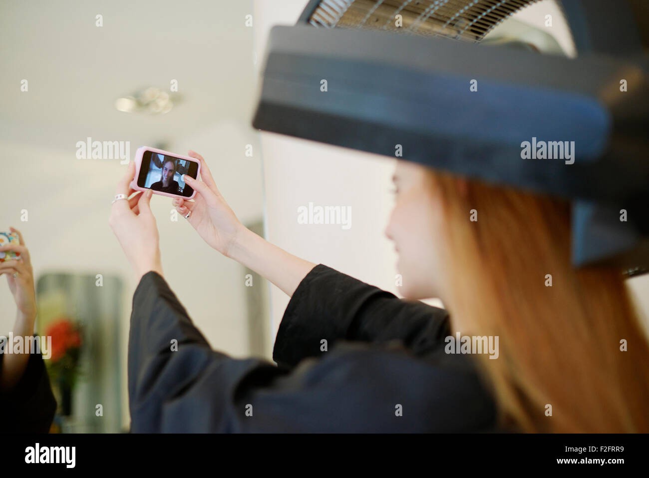 Il cliente tenuto selfie con la fotocamera del telefono nel salone di parrucchiere Foto Stock