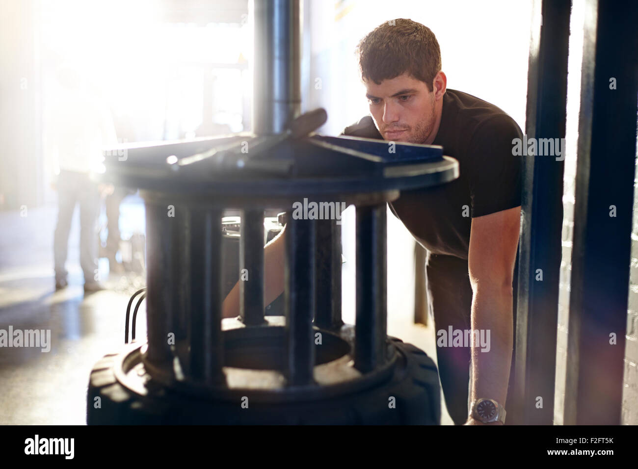 Mechanic utilizzando macchine per pneumatici in negozio di riparazioni auto Foto Stock