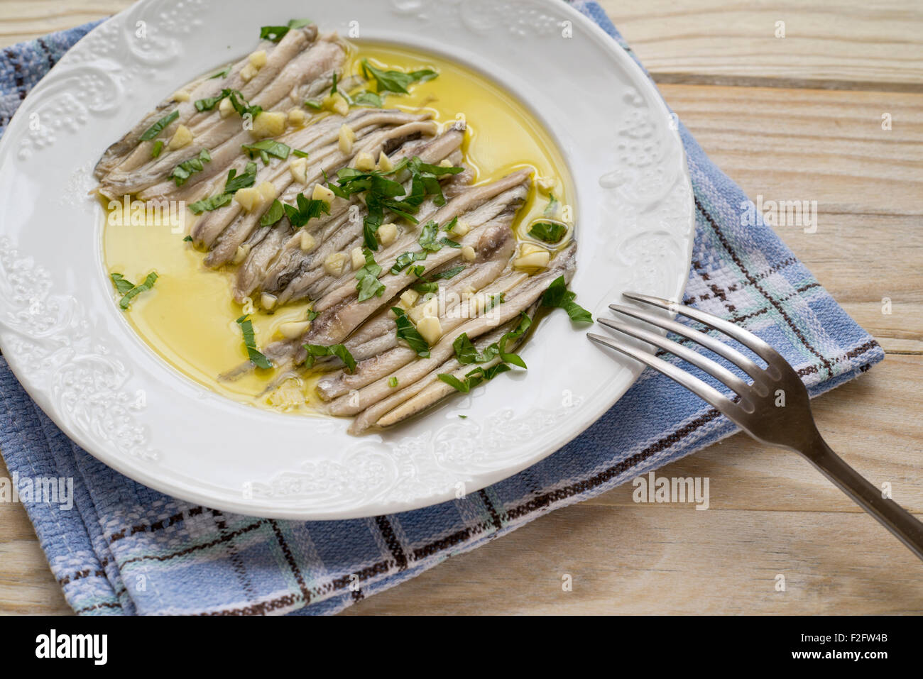 Boquerones: piccole in filetti di pesce (acciughe) conservati in olio di oliva, con spicchi di aglio e prezzemolo tritato. Molto popolari attraverso Foto Stock