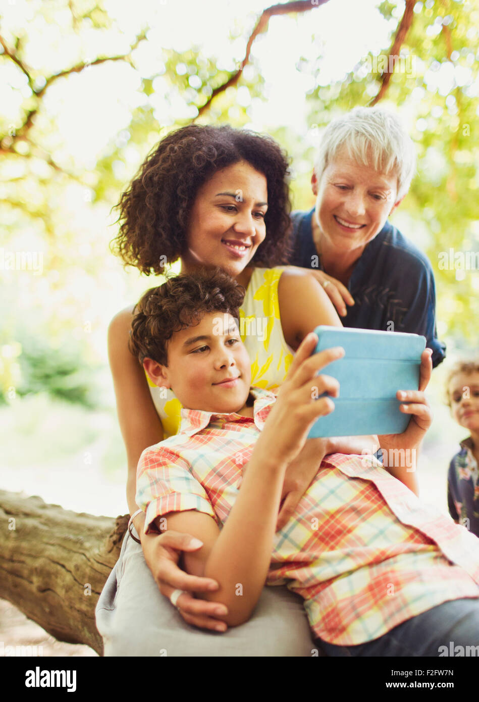 Multi-generazione famiglia utilizzando tavoletta digitale all'aperto Foto Stock