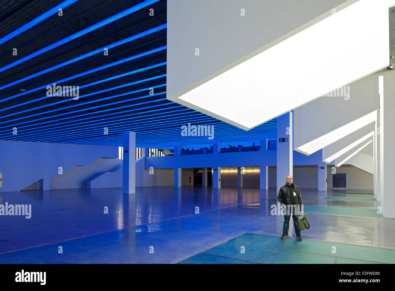 Lucernario colonne e piano terra gallery di luce blu con uomo in piedi. Museu del Disseny de Barcelona, Barcelona, Spagna. Arc Foto Stock