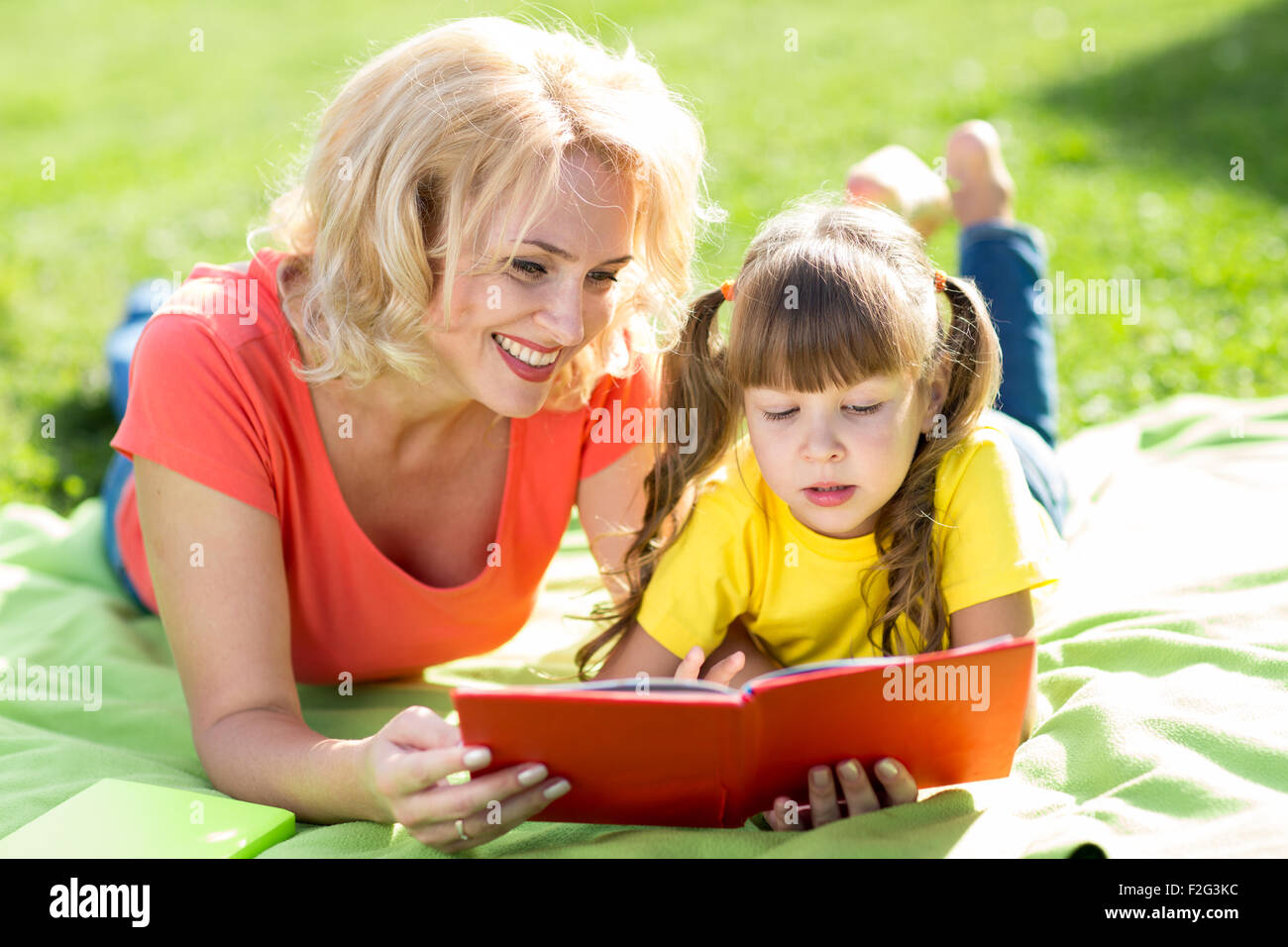 Madre e figlia e la lettura di un libro al parco. Foto Stock