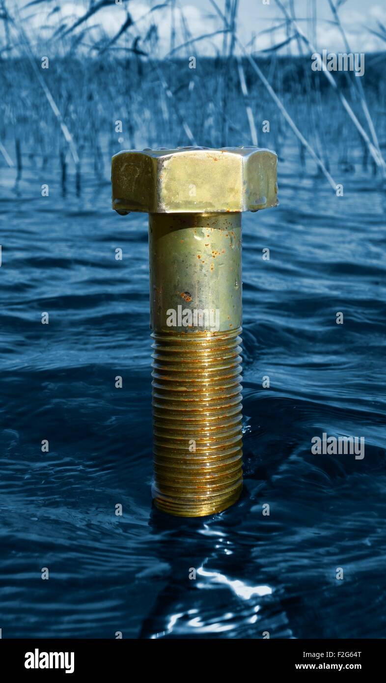 Un dado massiccio sorge fuori acqua blu Foto Stock