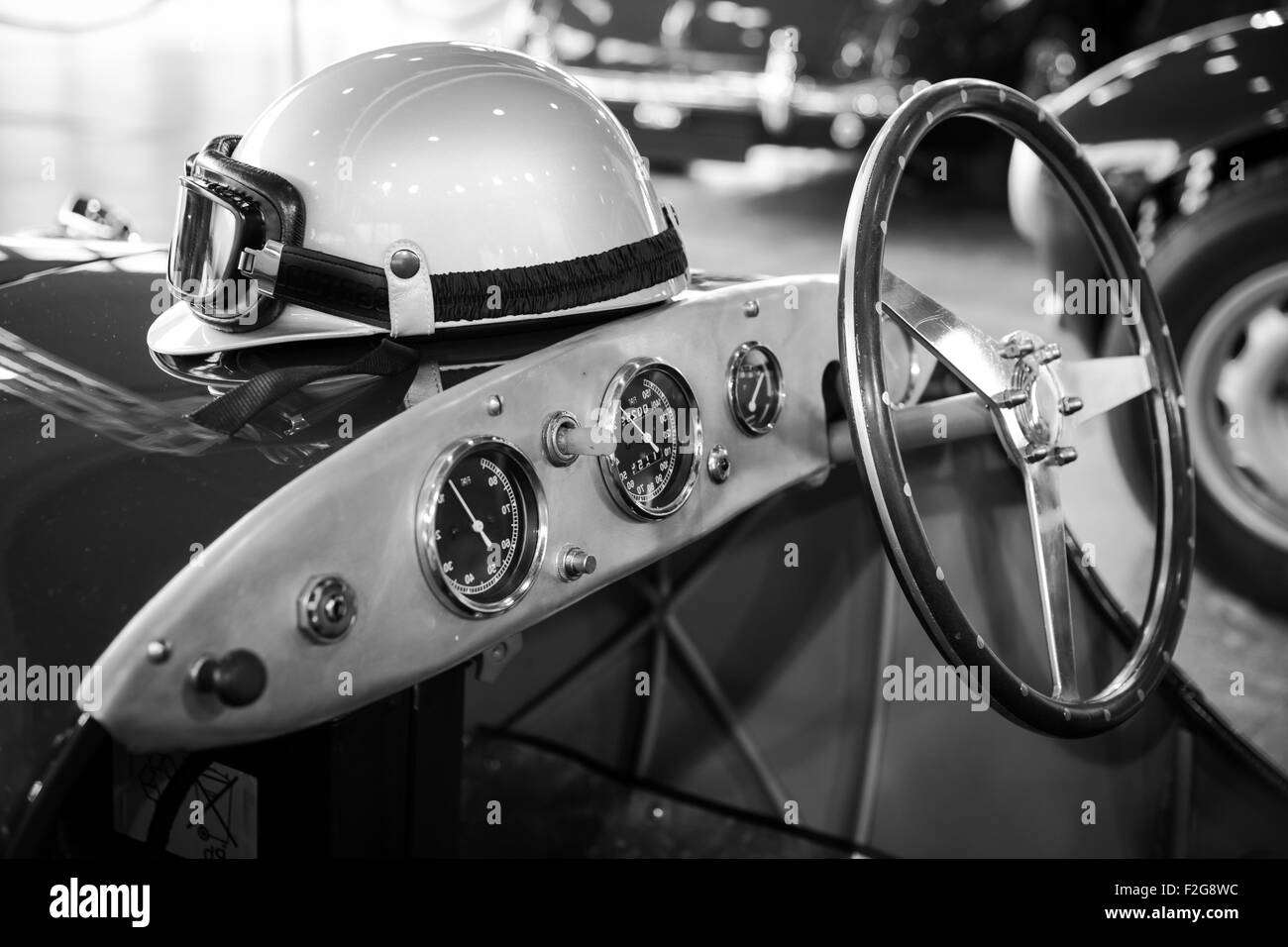 Casco e occhiali in appoggio su un vecchio vintage auto sportiva Foto Stock