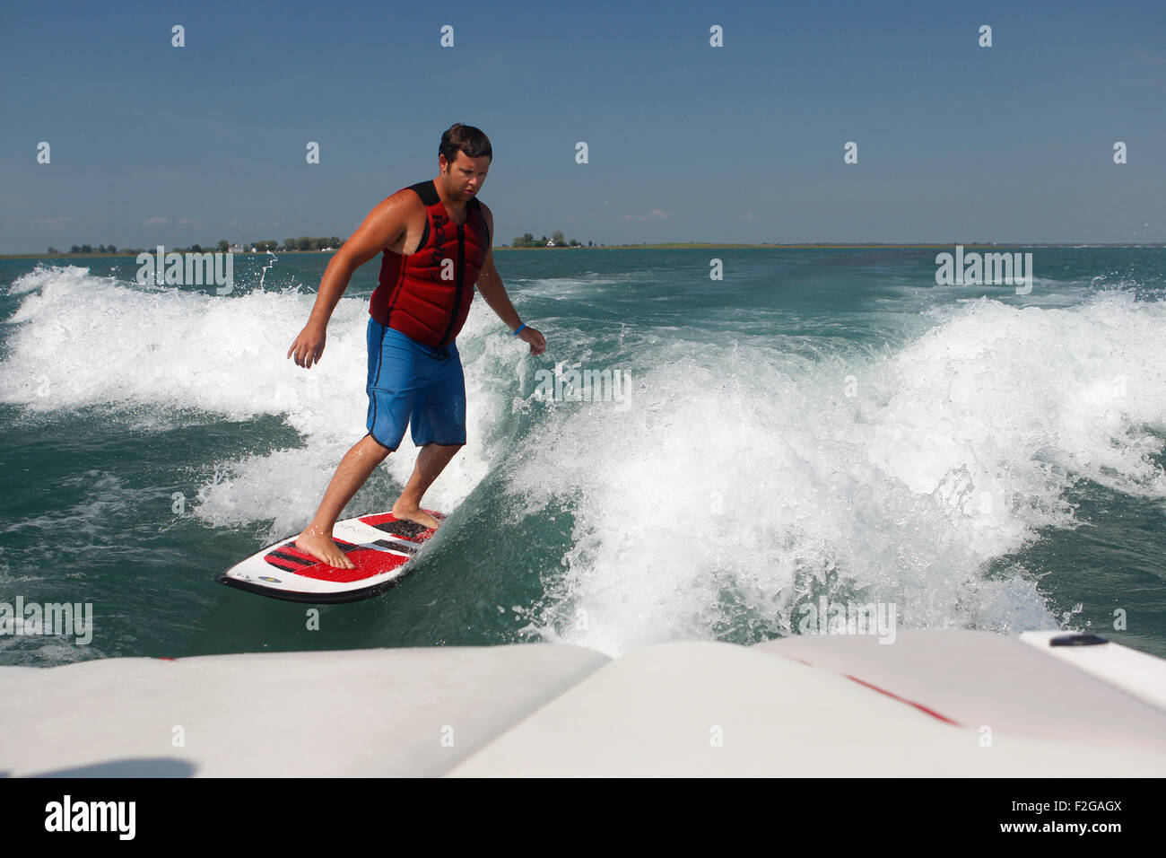 Un uomo wakesurfing dietro una barca. Foto Stock