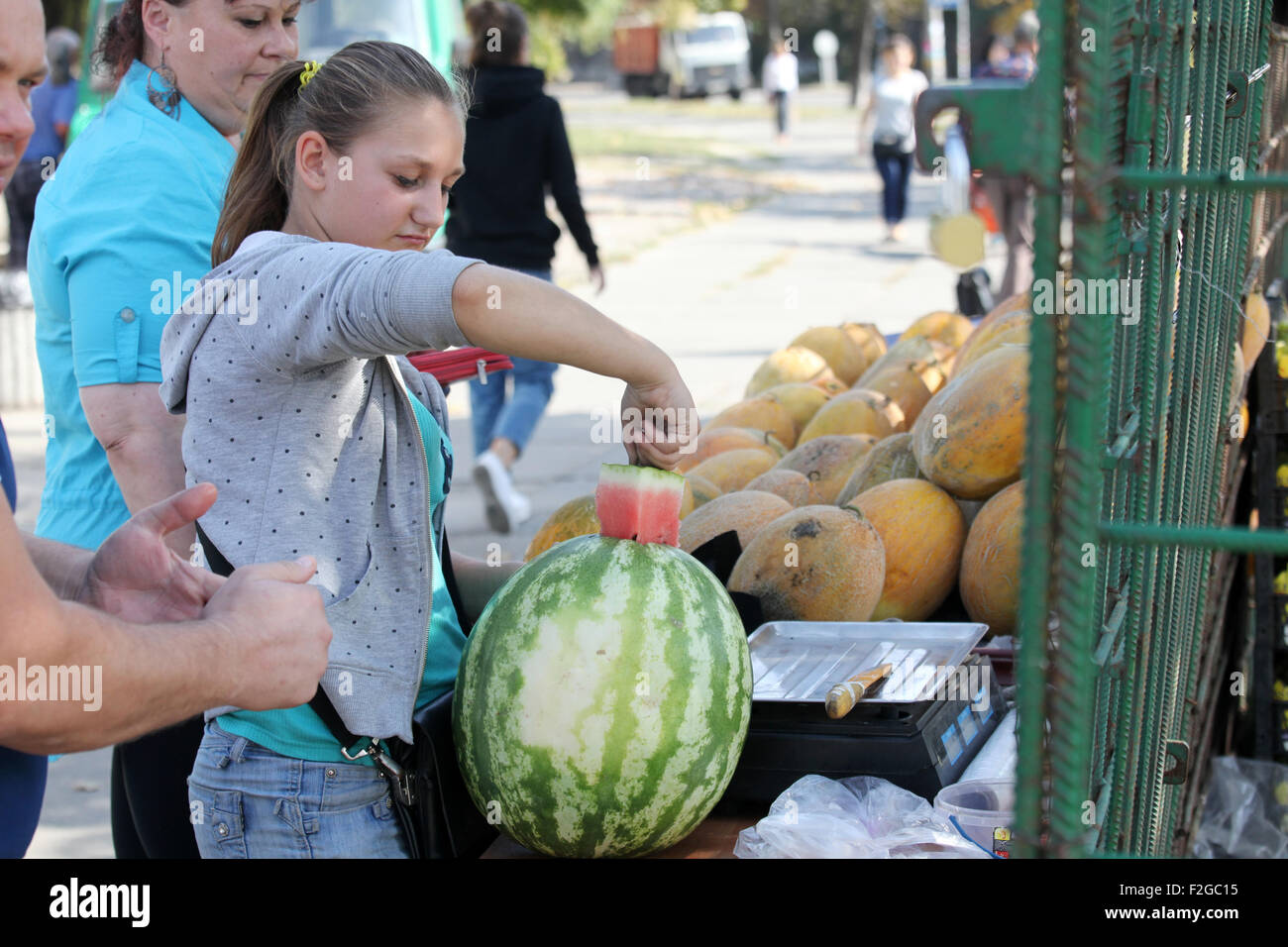 I prezzi economici dei meloni e dei meloni in Ucraina, 2015. La giovane donna offre un anguria tagliata a piacere Foto Stock