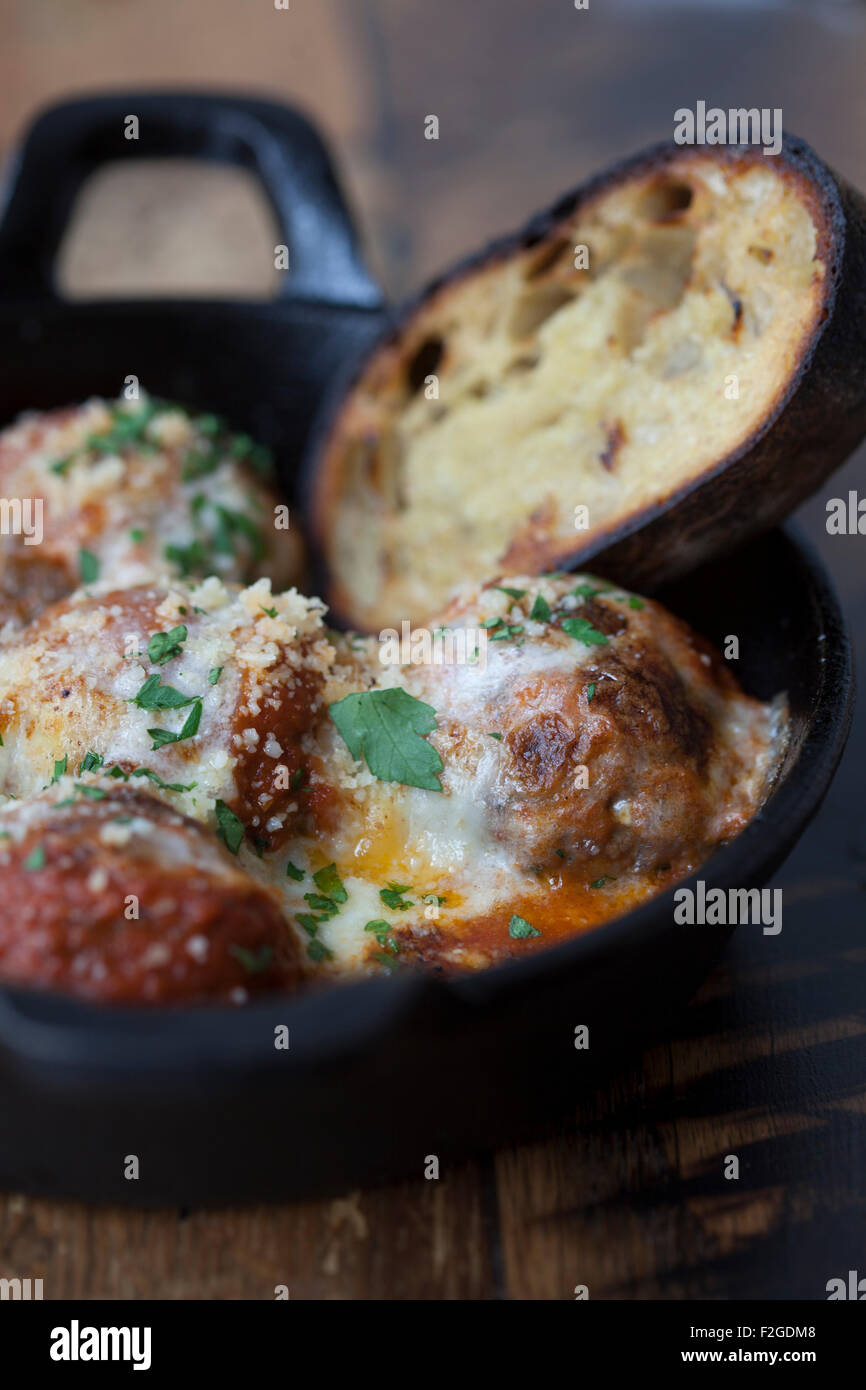 Le polpette di carne con salsa al formaggio in padella di ferro con pane Foto Stock