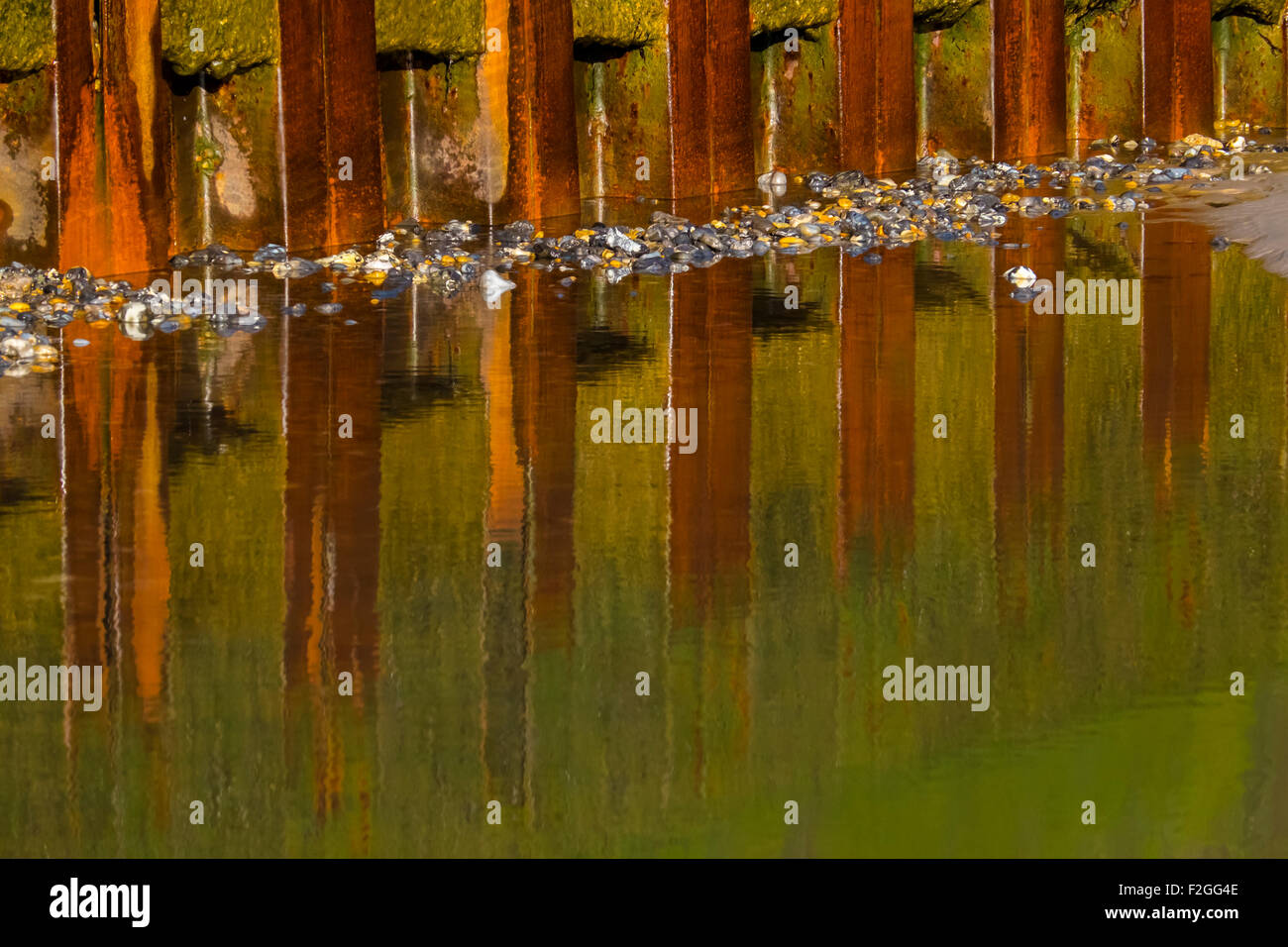 Acciaio arrugginiti riflessa in una piscina sulla spiaggia. Foto Stock