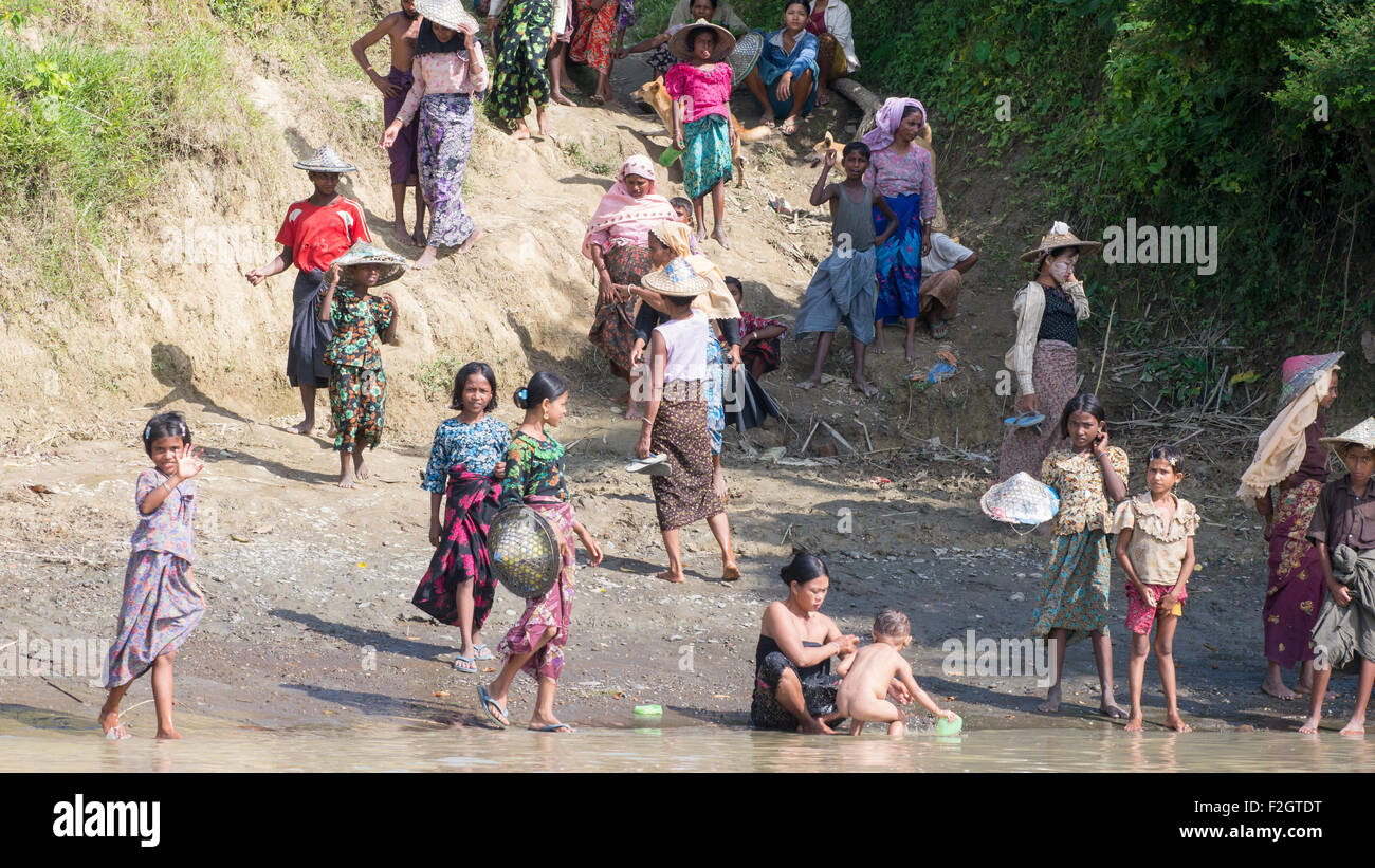 Persone di diversa origine etnica in attesa di un traghetto per essere trasportati attraverso il lay Myo River in Western Stato di Rakhine Foto Stock