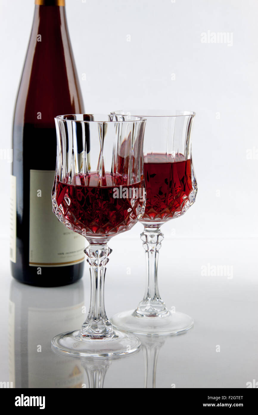 Una bottiglia di vino e due parzialmente riempito bicchieri Foto Stock