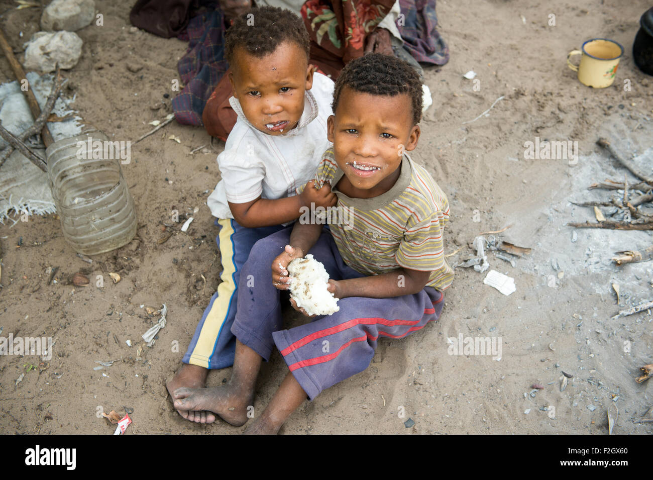 Due bambini a mangiare cibo nel loro villaggio in Botswana, Africa Foto Stock