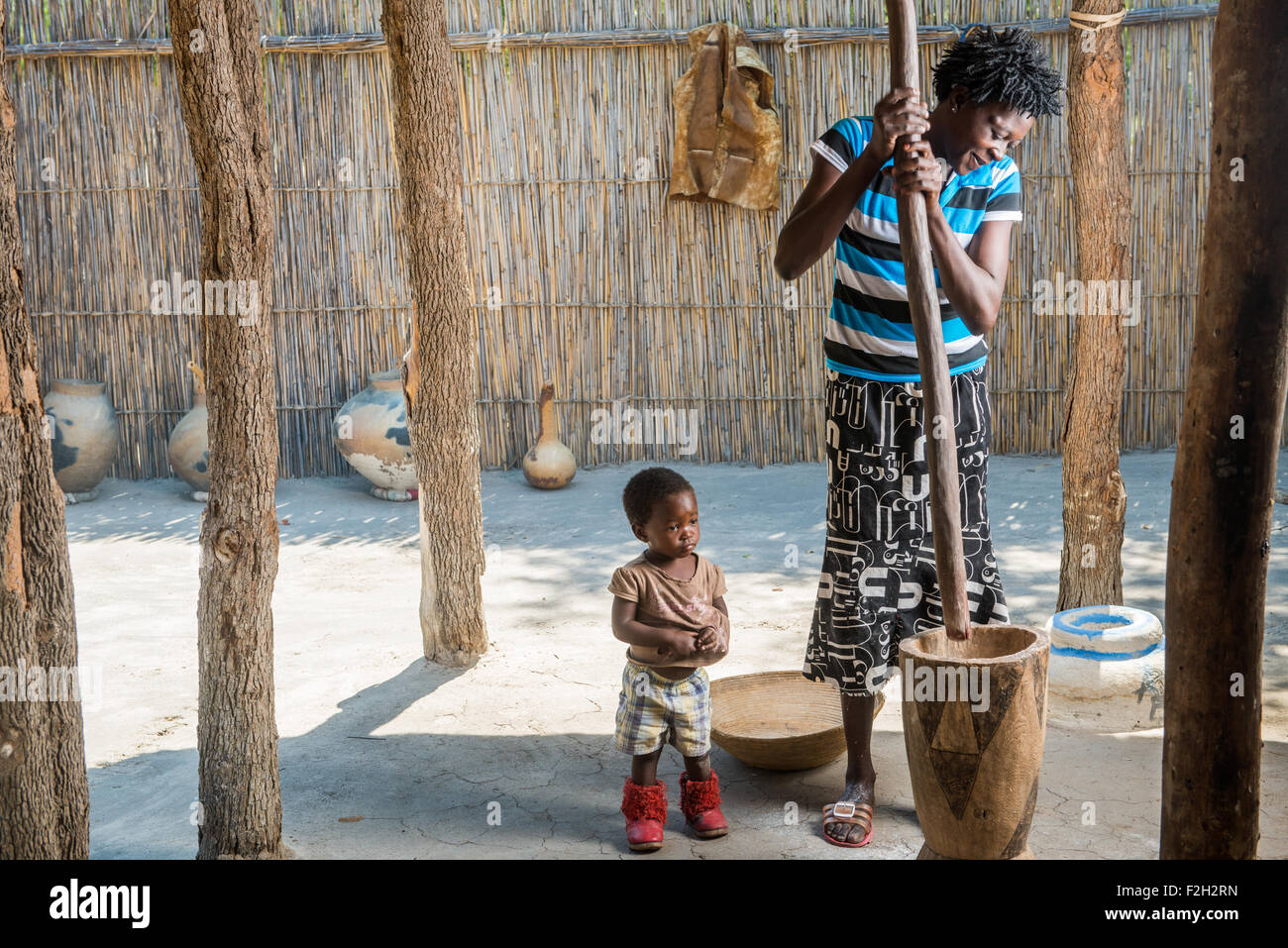 Donna africana e del suo bambino cucinare la cena per la propria famiglia in Botswana, Africa Foto Stock