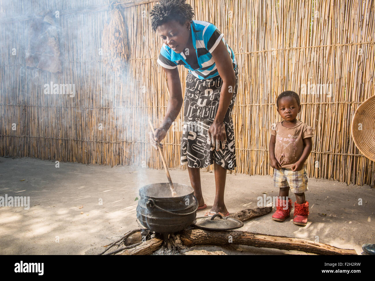 Donna africana e del suo bambino la cottura di cibo per la famiglia in Botswana, Africa Foto Stock