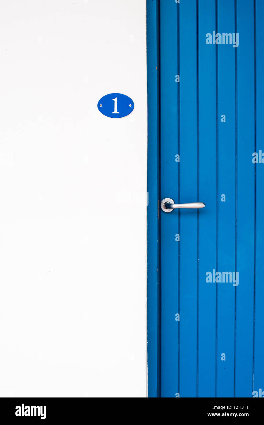 Numero uno sportello blu parte muro bianco con copyspace Foto Stock