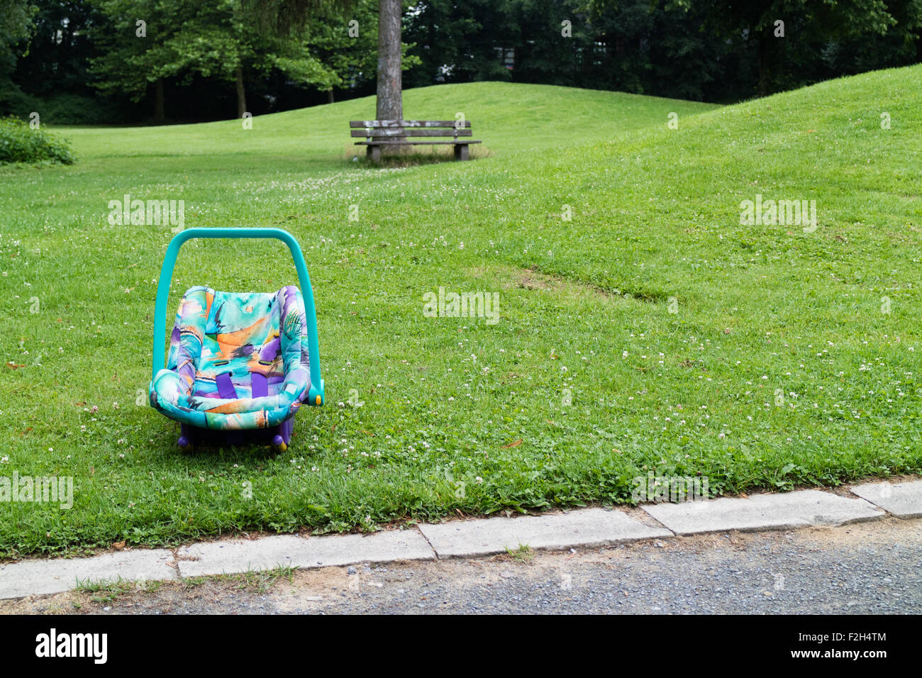 Un bambino abbandonato il sedile auto in un parco Foto Stock