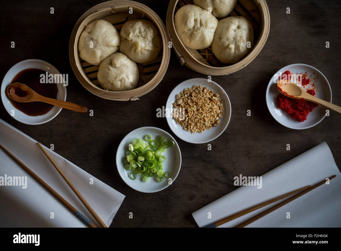 Asian street food in bambù vaporetti sul tavolo di legno. Vista dall'alto. Foto Stock