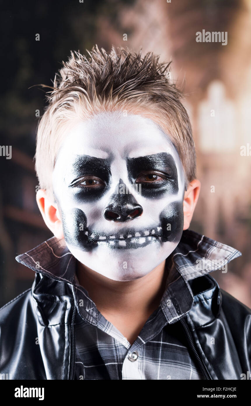 Scary piccolo ragazzo che indossa il trucco del cranio Foto Stock