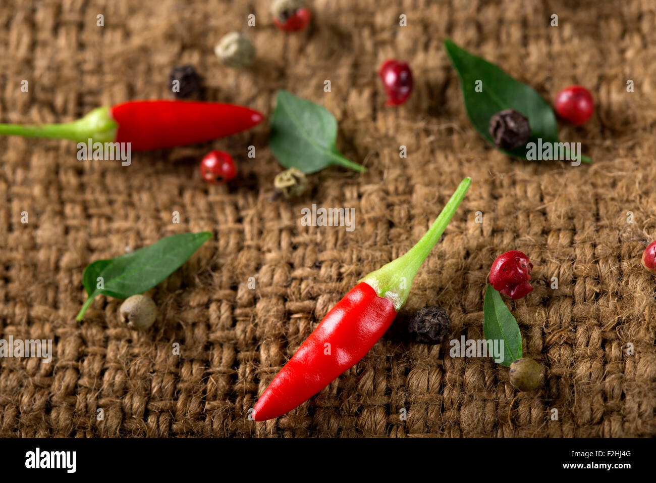 Alcuni piccoli freschi red hot chili peppers sul vecchio rustico sacchetto tessile Foto Stock