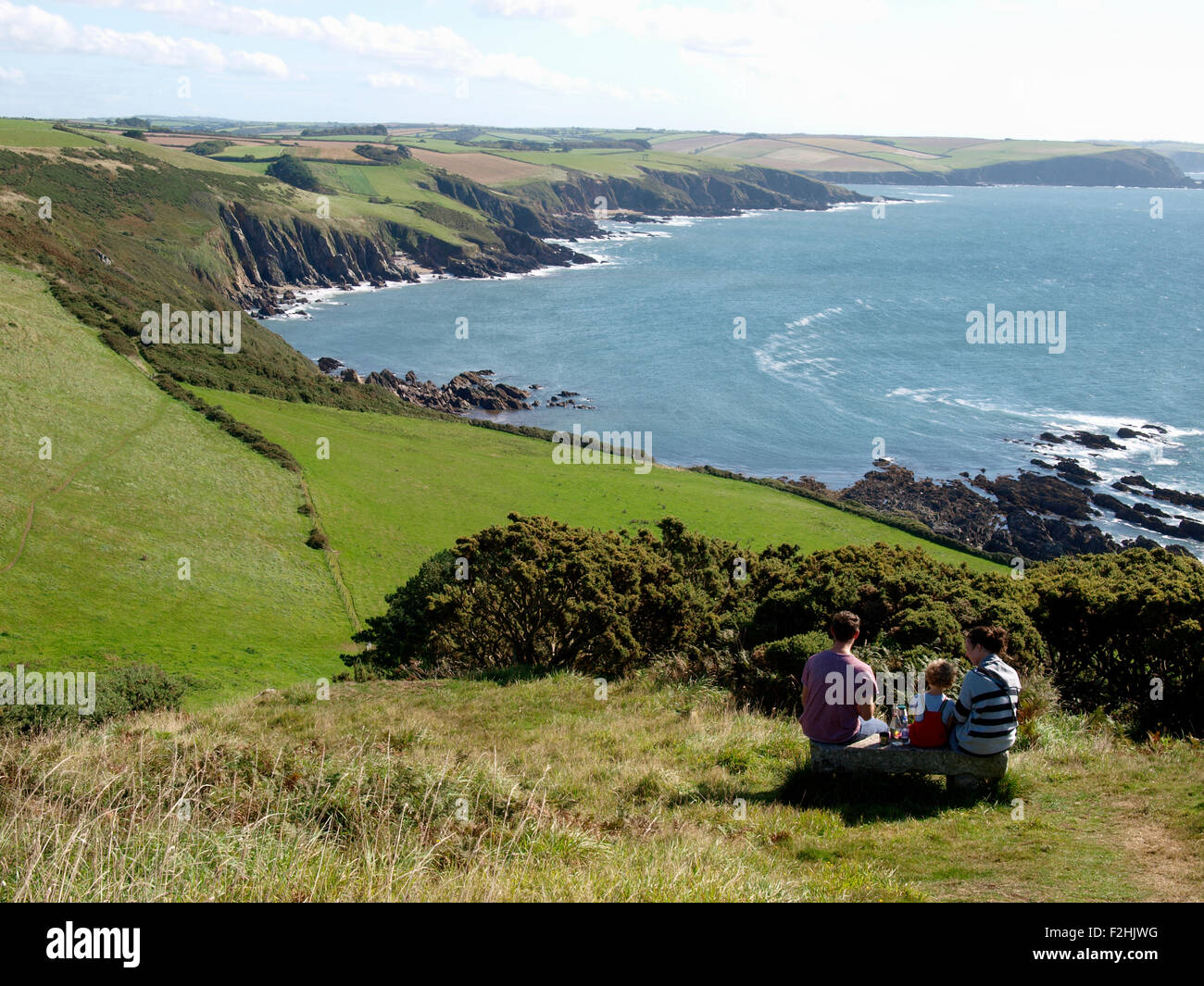 Famiglia di mangiare un picnic lungo la costa sud-ovest il percorso nei pressi di Noss Mayo, Devon, Regno Unito Foto Stock