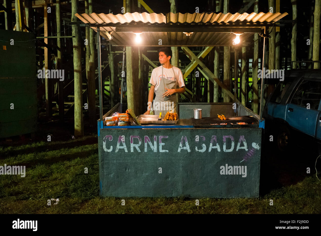 Un uomo cuochi carne su una griglia aperta di notte per festaioli a bi Villareal annuale Fiesta, vicino a Tamarindo, Costa Rica Foto Stock