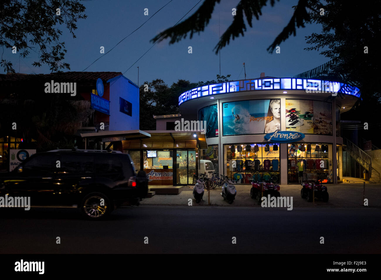 Un grande negozio di surf e retail store di notte è uno di Playa Tamarindo di molti negozi di articoli da surf e scuole in Guanacaste in Costa Rica Foto Stock
