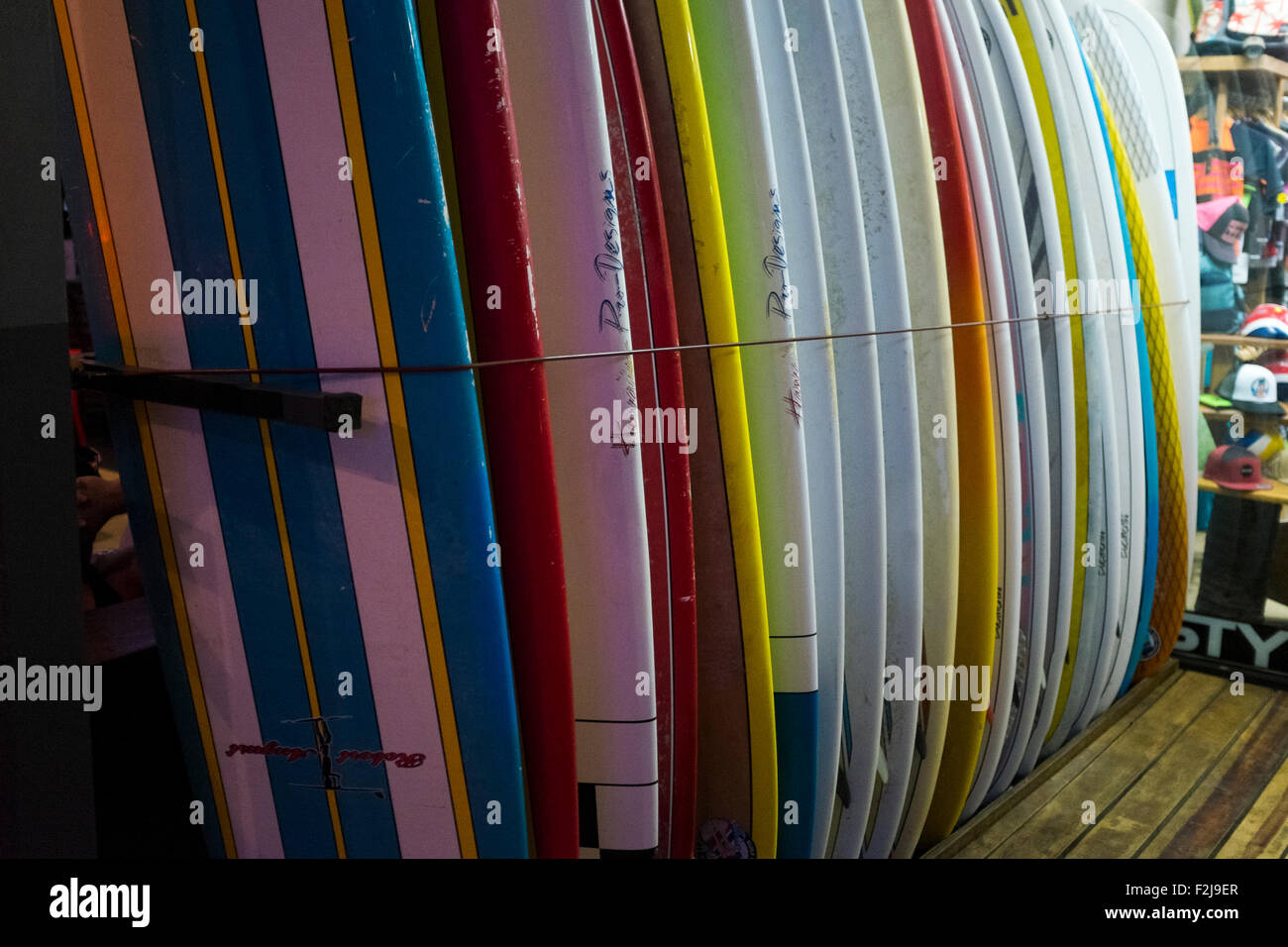 Un rack delle colorate tavole da surf al di fuori di uno di Playa Tamarindo di molti negozi di articoli da surf e scuole in Guanacaste in Costa Rica Foto Stock