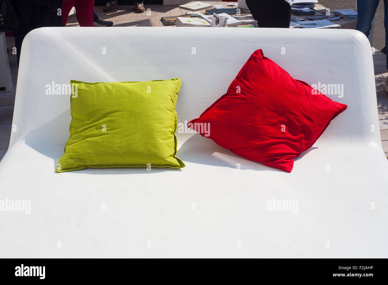 Vista del verde e rosso e cuscini sul letto bianco Foto Stock