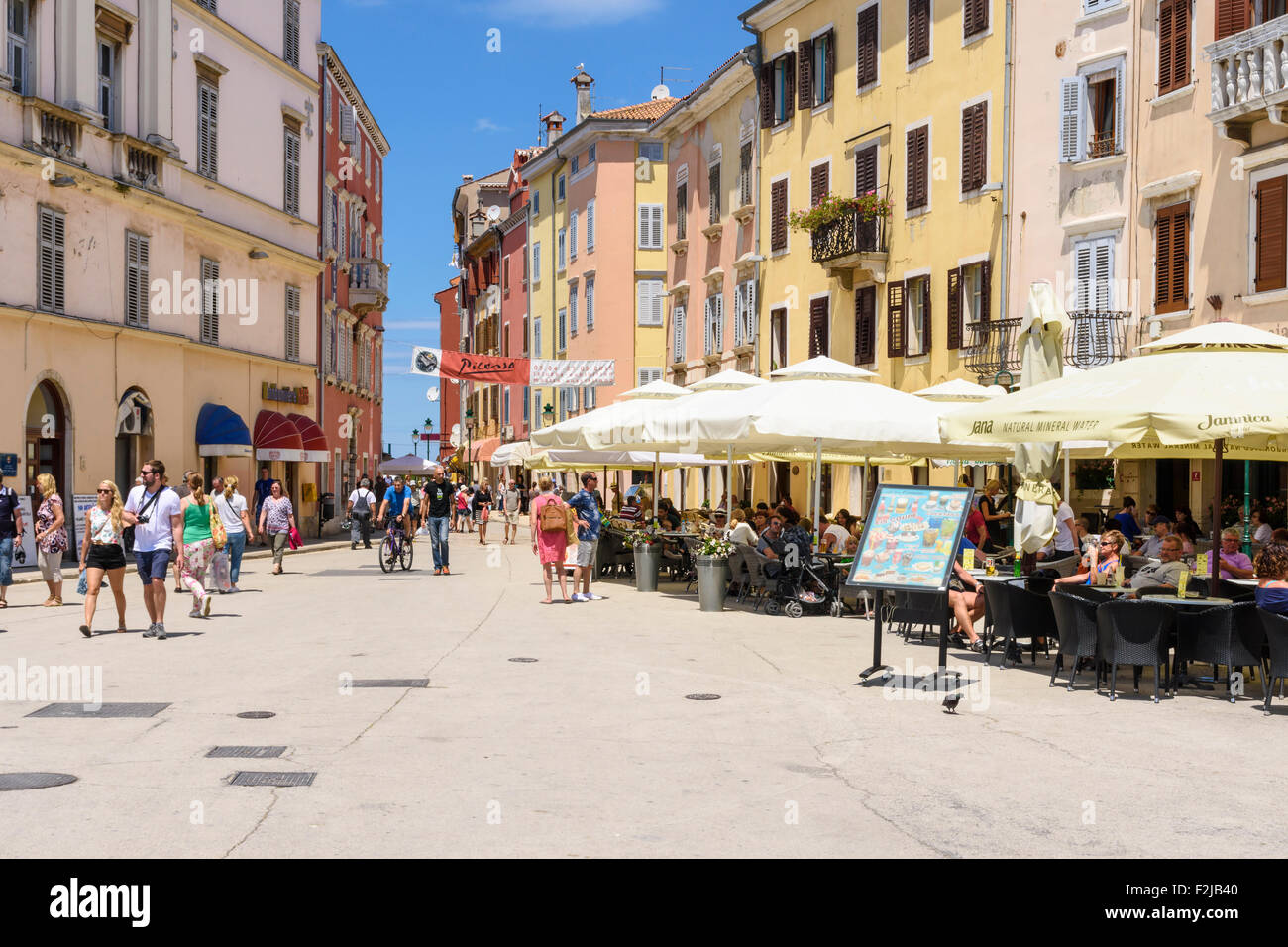 Gli edifici colorati e ombreggiata cafe nella città vecchia di Rovigno, Istria, Croazia Foto Stock